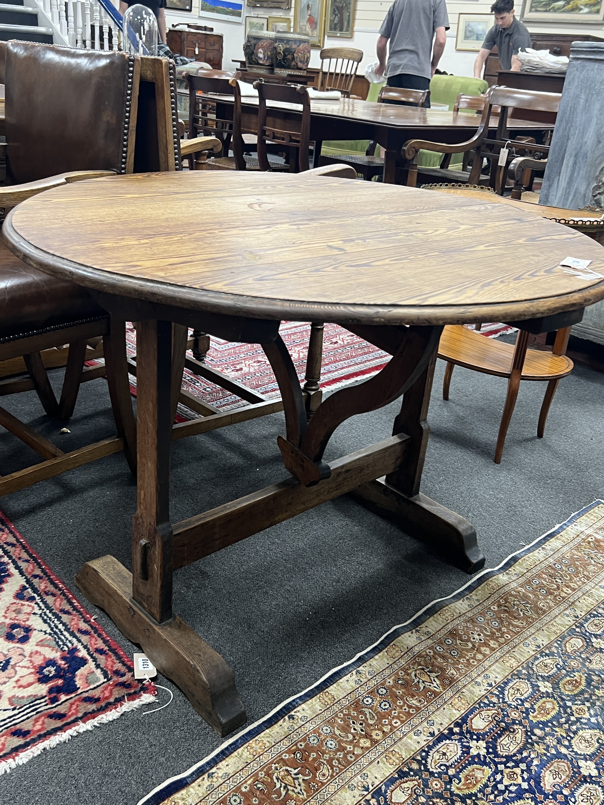 A 19th century French oval oak and pine tilt top folding table, width 90cm, depth 100cm, height 72cm